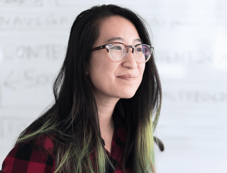 a woman with glasses and a plaid shirt