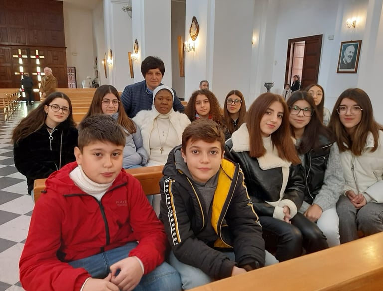 A diverse group of students sitting on wooden pews inside a cathedral for a school event.