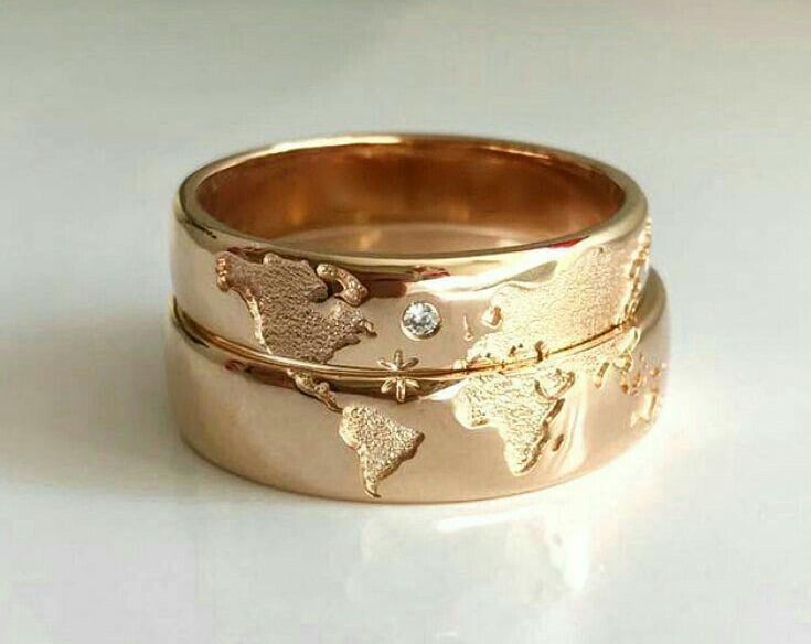 "Alianzas de boda a juego en oro rosa con el mapa del mundo, continentes grabados y un sutil detalle