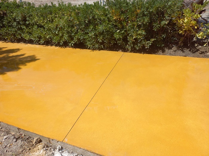 Hormigón pulido color amarillo para camino exterior.