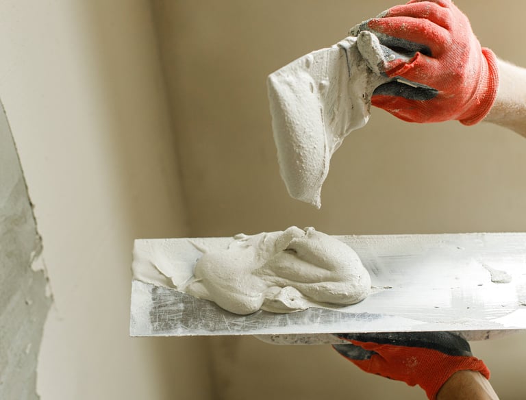 Handwerker beim Spachteln einer Wand im Rahmen von Malerarbeiten in Aachen
