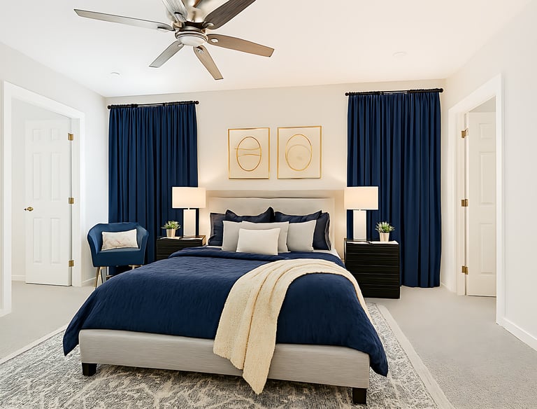 Modern bedroom interior with a blue comforter, navy curtains, and gold wall art frames.