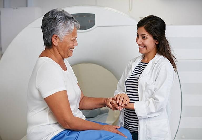 Doctor consulting senior patient after MRI scan at Delhi facility.
