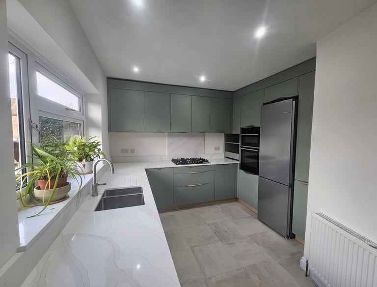 a kitchen with a large window and a potted plant