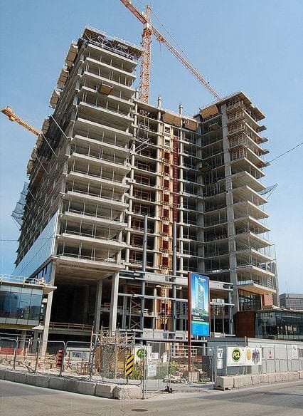 a large building with a crane in the foreground