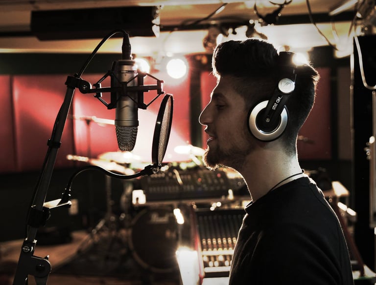 a man in a recording studio with headphones sings a song