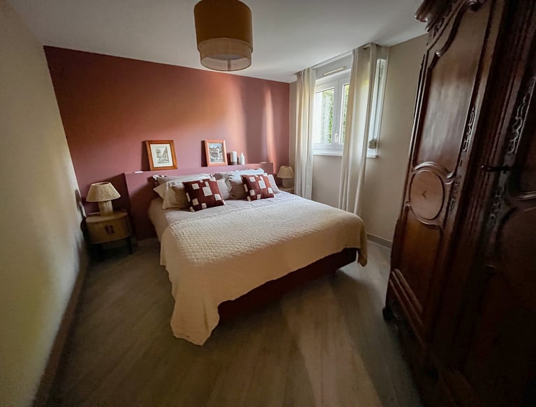 a bedroom with a bed and a wooden cabinet