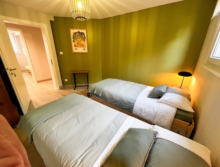 a bedroom with two beds and a lamp