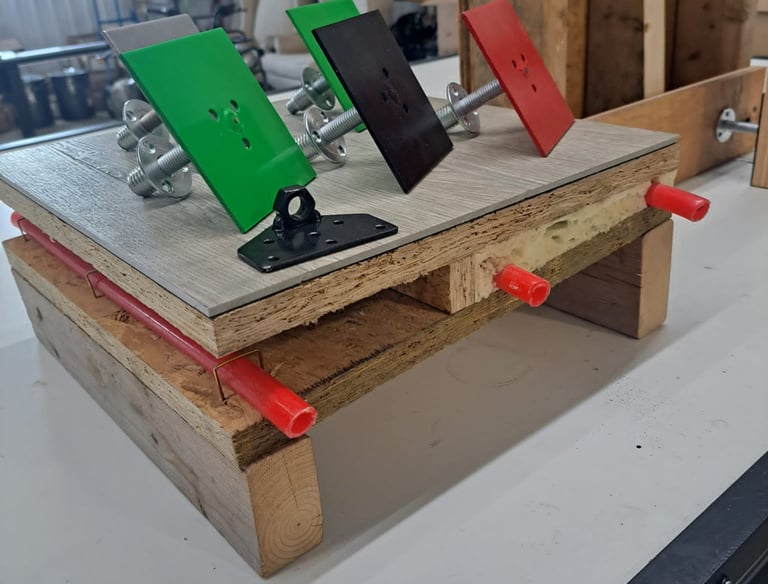 Mounted color-coded anchor plates displayed on a construction test setup for framing and insulation systems