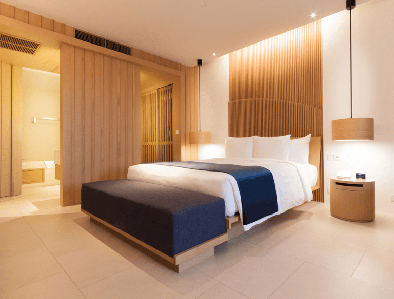 Quarto com cama arrumada, iluminação inteligente e cortina motorizada