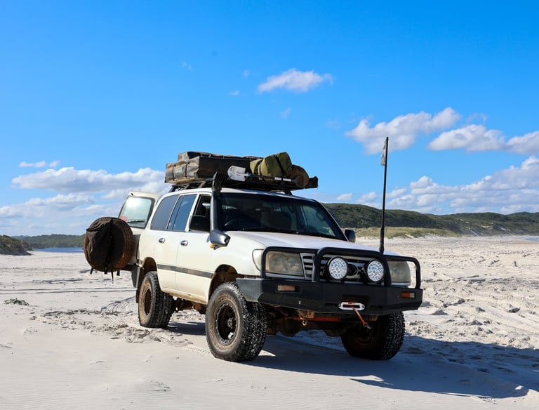 Toyota Land Cruiser 4x4 rijdend over een afgelegen strand in de outback van West Australië