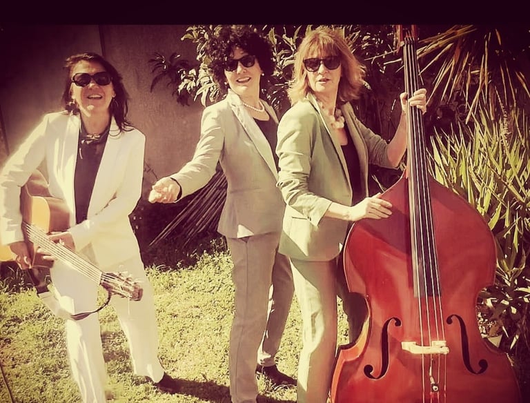 trois femmes en costume avec une contrebasse et une guitare