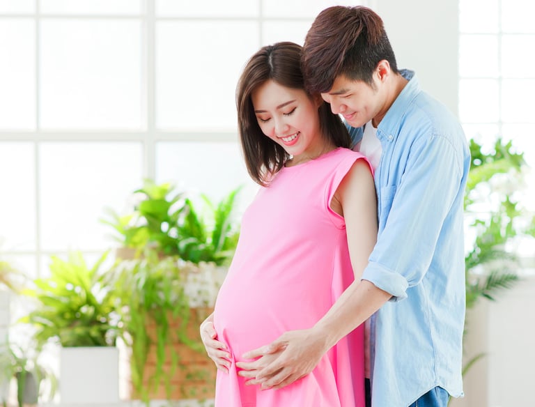 Pregnant lady hugged from back by a supportive and caring partner