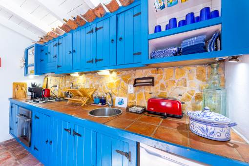 a kitchen with blue cabinets and a red refrigerator