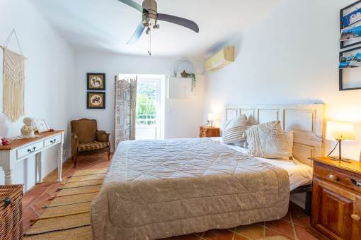 a bedroom with a bed and a ceiling fan