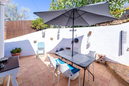 a patio with a table and chairs and umbrella