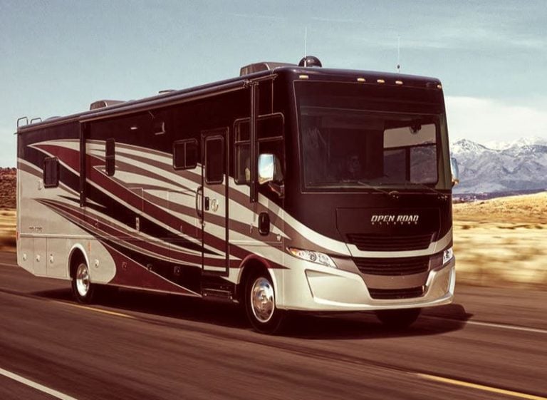Tiffin Allegro Open Road Class A motorhome driving on a highway with mountain scenery.