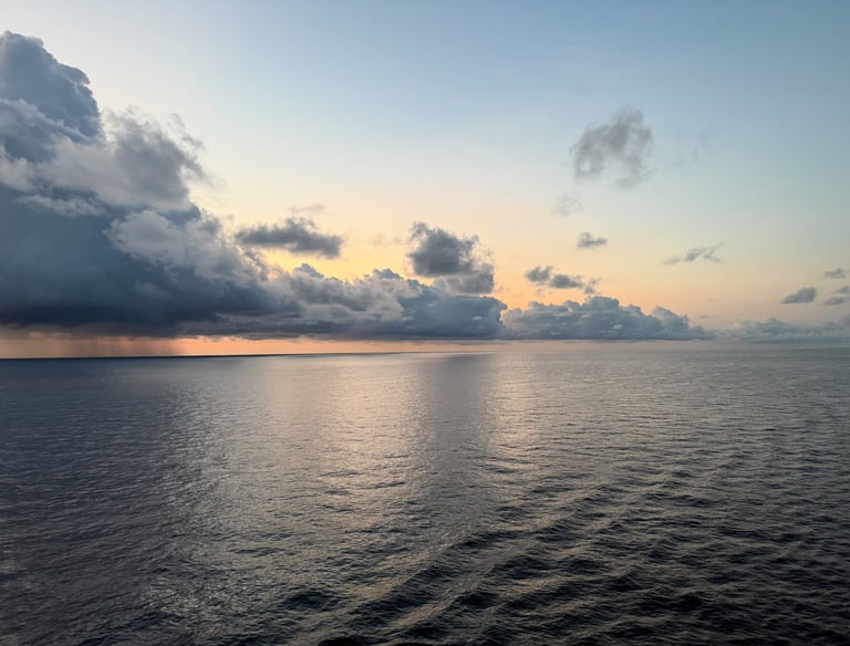 a boat in the water with clouds in the background