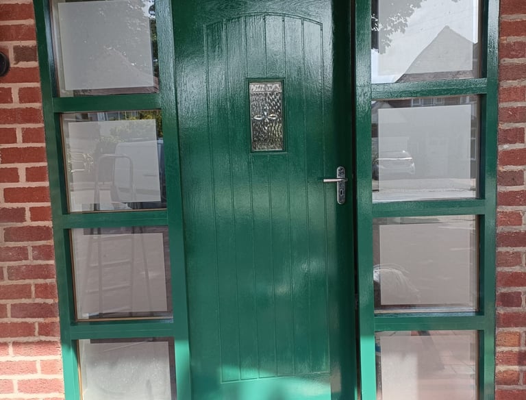 a freshly painted green door with a number on it