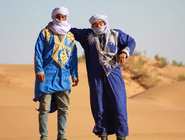 Two men wearing traditional nomad dress in the Moroccan Sahara desert