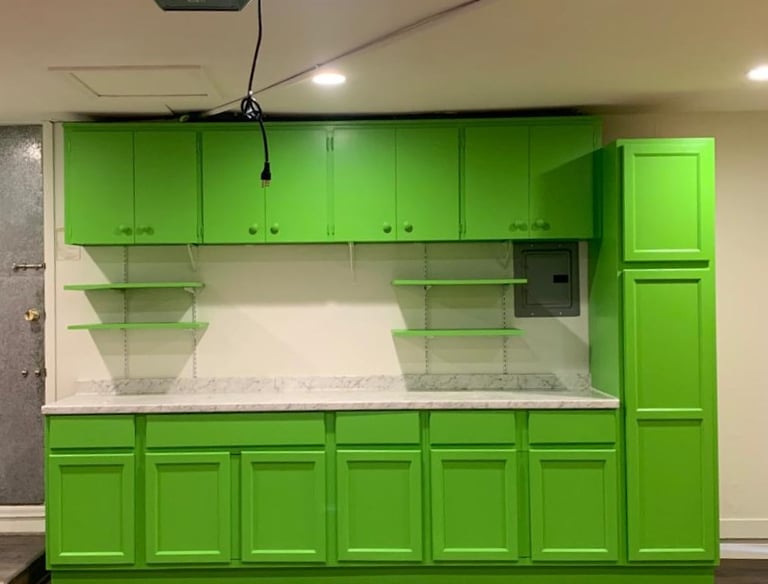a kitchen with green cabinets and white counter tops