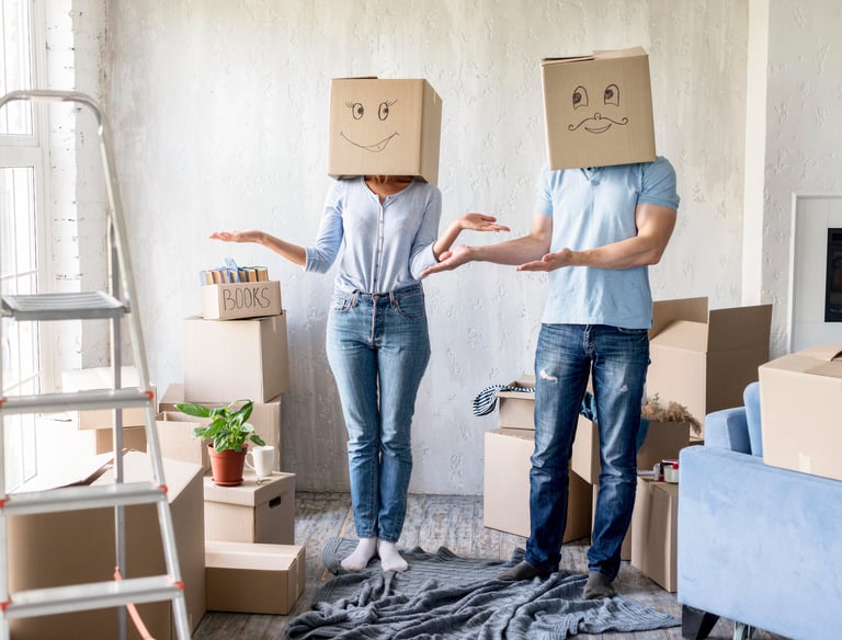 Woman and man moving in, wearing boxes on their head with funny faces drawn on them.
