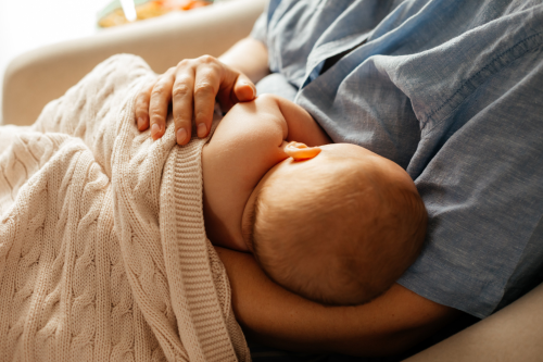 a baby is laying on a couch with a baby