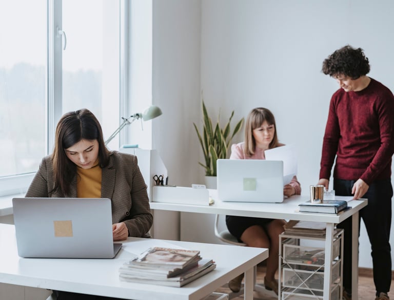 Personas trabajando en sus escritorios con computadoras 