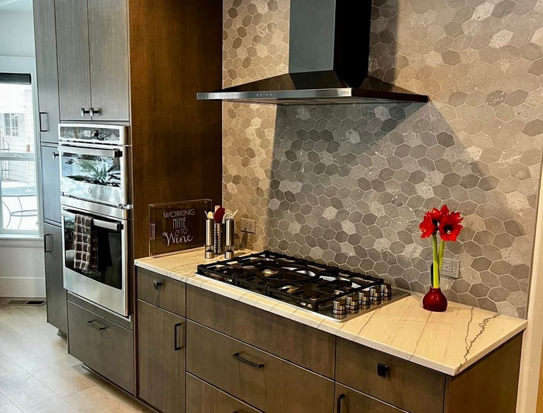 Modern kitchen featuring brown wood cabinets, a black vent hood, and a grey hexagon tile backsplash.