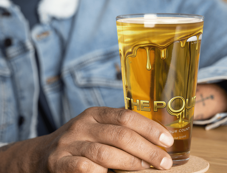 The Pour Shop branded pint glass shown in packaging box with materials demonstrating hospitality merchandise presentation