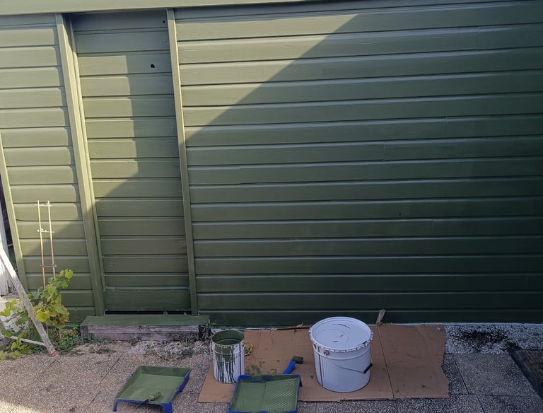 a garage door with a bucket of paint and a bucket of paint