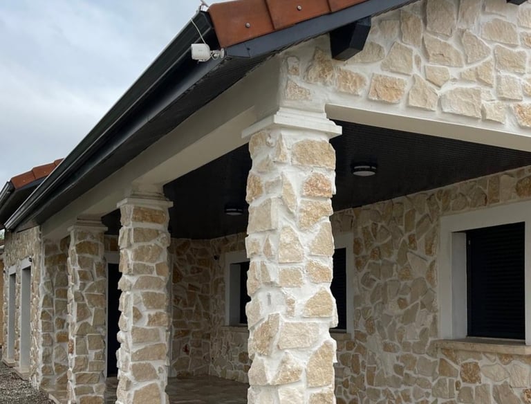 a house with a stone wall and a brick wall