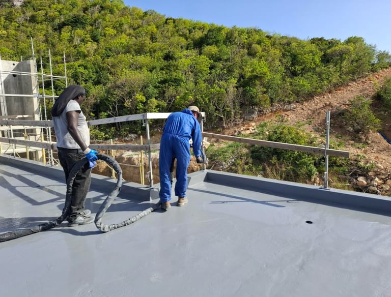 Construction workers applying a grey waterproof coating to a flat roof at The Hills Residence