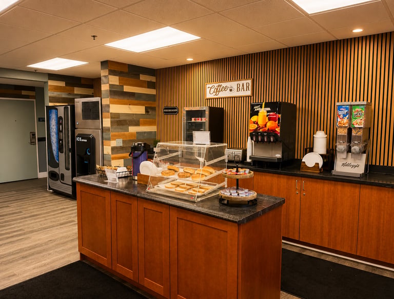Hotel breakfast bar area featuring fresh bagels, cereal dispensers, and a coffee station.