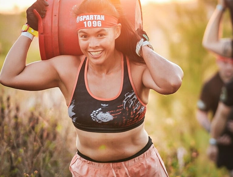 Janice McDonald carrying a heavy bucket during a Spartan Race obstacle course in Boca Raton.