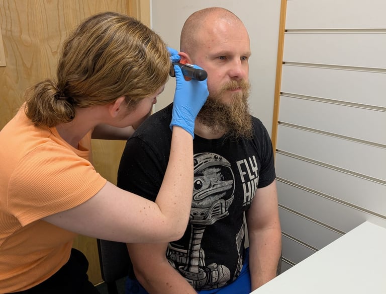 pharmacist prescriber using otoscope to perform ear examination pharmacy first plus consultation
