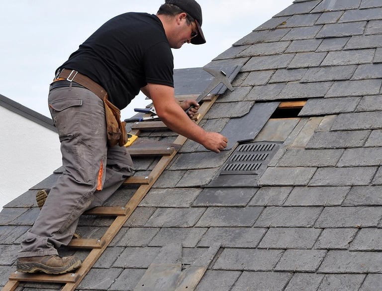 Roofing Specialists Yorkshire. Roofer repairing damaged roof tiles