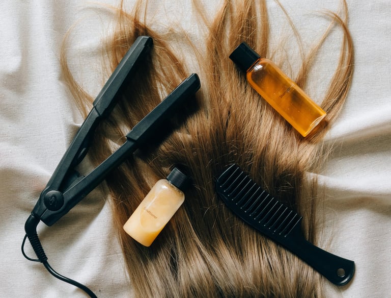 Plancha para el cabello, peine y botellas de shampoo tamaño de viaje sobre cabello.