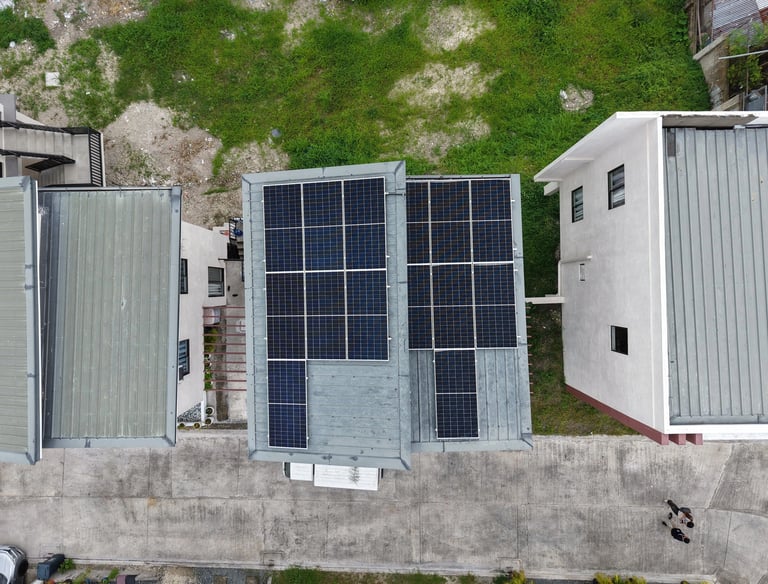 Aerial view of residential solar panel installation on a flat rooftop for renewable energy.