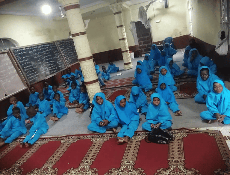 Children in blue uniforms attending mosque-based Qur’an and Islamic education for new Muslims – Sier