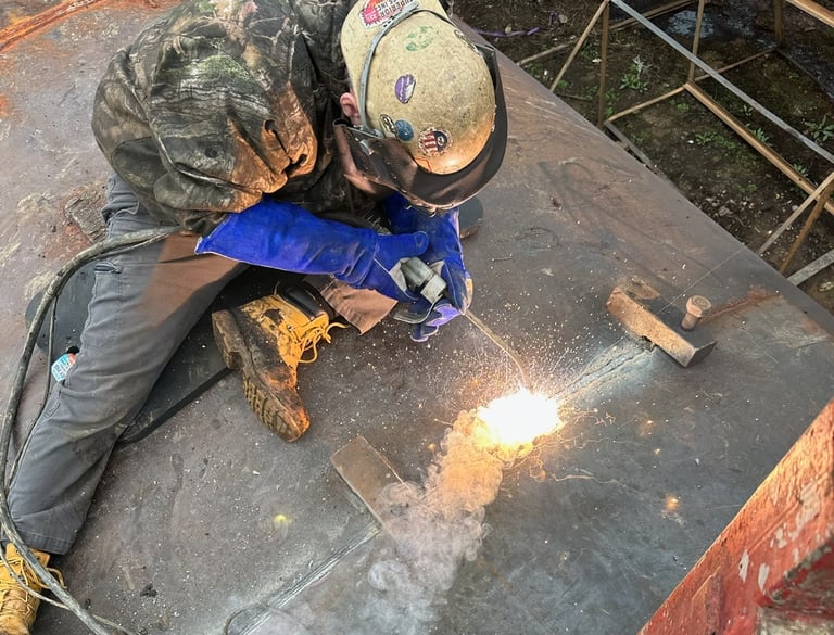 a man in a helmet welding a metal pipe