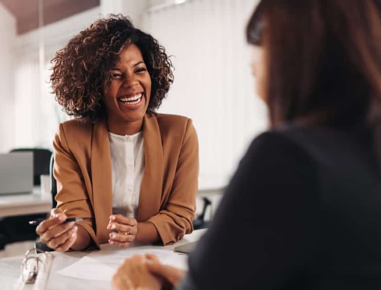 a woman in a business suit sitting at a table