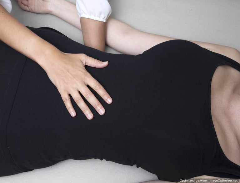 image of a craniosacral therapists hands resting on the body of a female client