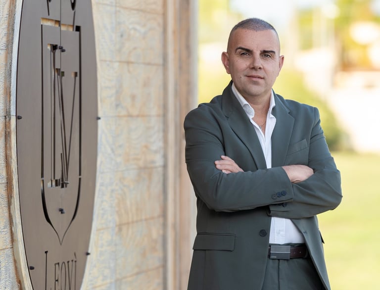 a man in a suit and white shirt standing in front of a clock