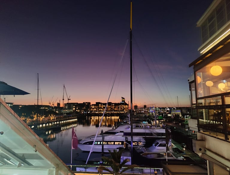 Viaduct Marina, Auckland, New Zealand. View of sunset, city lights and moored yachts