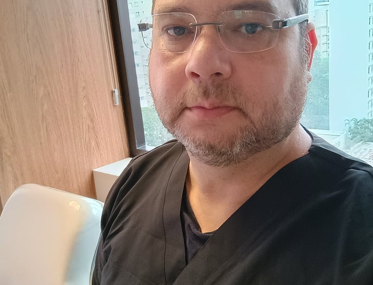 Dr. José Eri, especialista odontologia do sono, vestindo uniforme médico preto em um consultório.