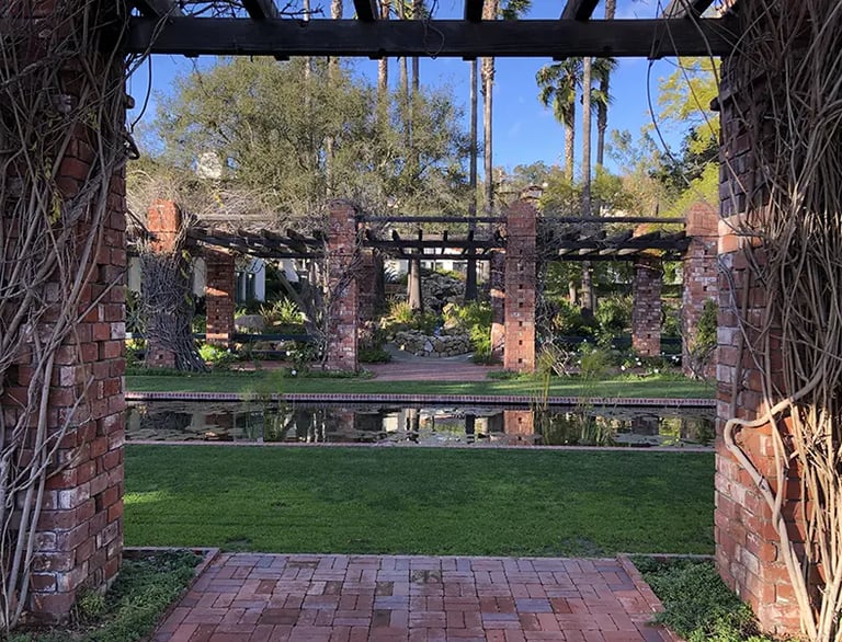 Vine-covered brick trellis and pond at the Santa Barbara El Encanto Hotel.