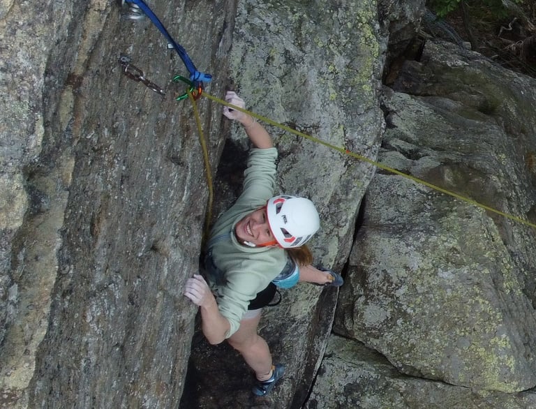 Climbing participant is happy about completing the route on an outdoor climbing course.