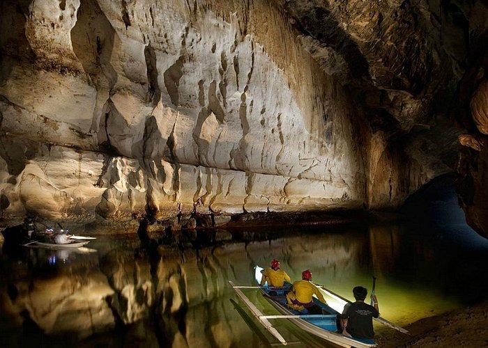 Tourists in a small boat explore the Puerto Princesa Subterranean River cave system in the Philippines.