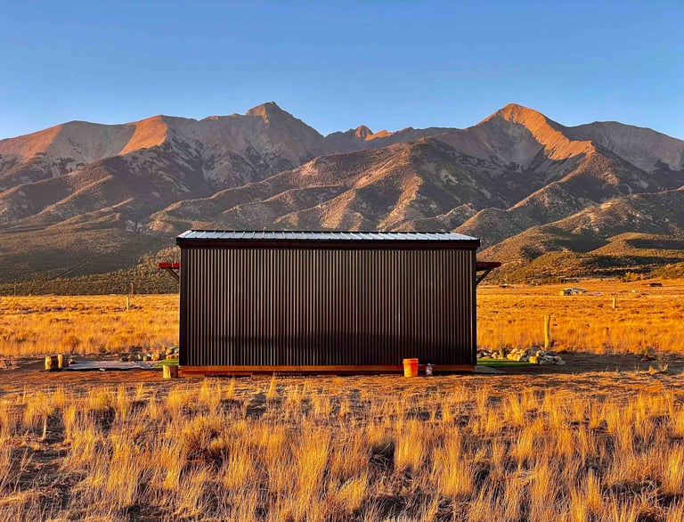 a small cabin with a mountain in the background